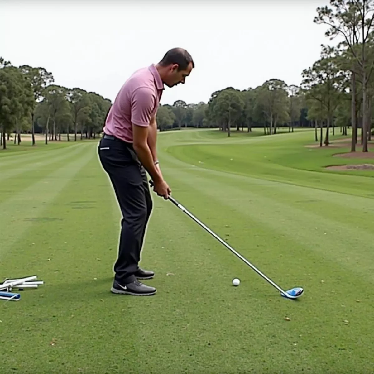 Golfer Using Alignment Sticks For Practice