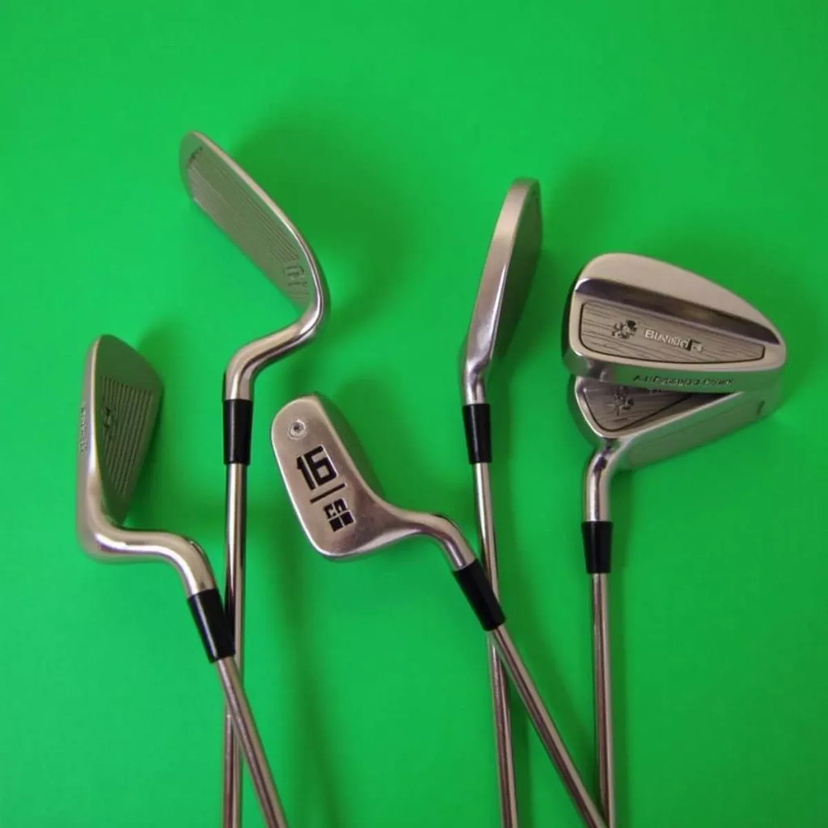 Classic Golf Blade Irons Displayed On A Green Background